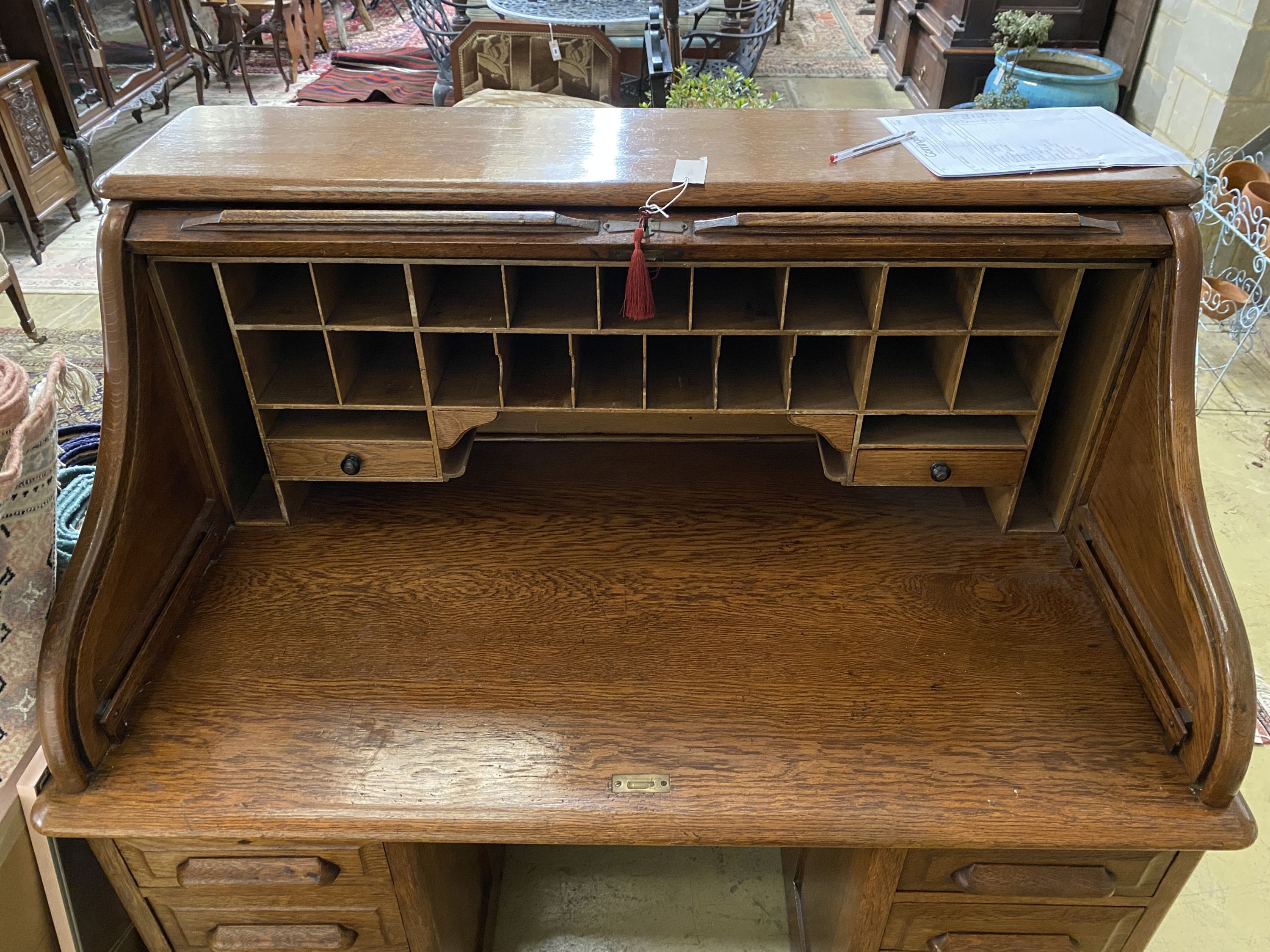 An early 20th century oak roll top desk with 'S' shaped tambour, width 122cm, depth 78cm, height 124cm